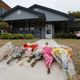 In this Monday, Oct. 14, 2019 photo, flowers lie on the sidewalk in front of the house in Fort Worth, Texas, where a white Fort Worth police officer Aaron Dean shot and killed Atatiana Jefferson, a black woman, through a back window of her home. Dean was not heard identifying himself as police on the bodycam video, and Interim Police Chief Ed Kraus has said there was no sign Dean or the other officer who responded even knocked on the front door. Dean resigned before being charged with murder.